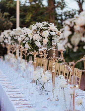 In questa foto un lungo tavolo imperiale, con candelabri e fiori, allestito per un matrimonio curato da Maria Macchiarella Wedding Planner